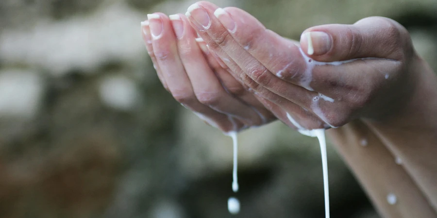 Persons Hands Covered in White Liquid