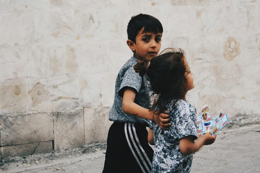 Photograph of a Boy Walking with His Sister