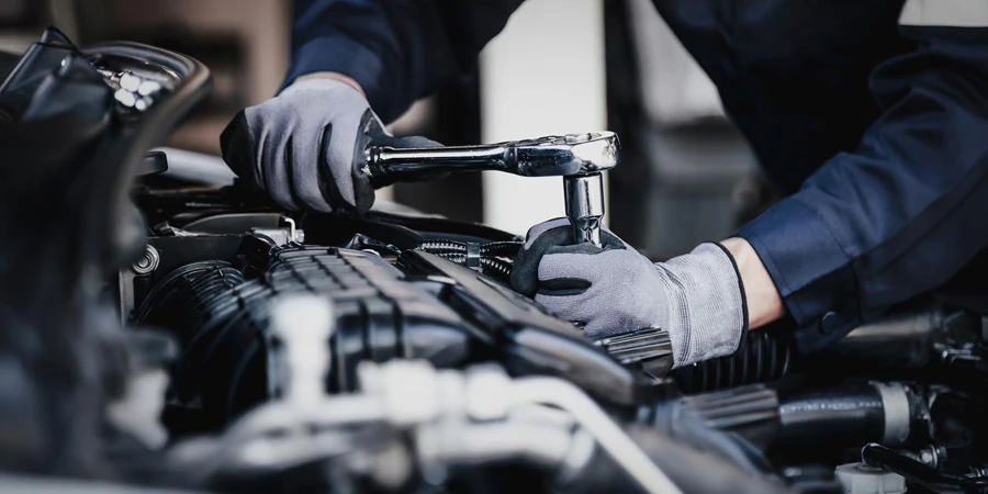 Professionele monteur die in de garage aan de motor van de auto werkt