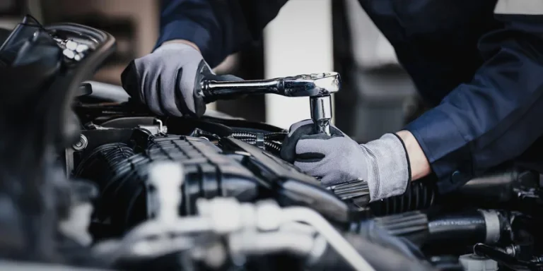 Professional mechanic working on the engine of the car in the garage