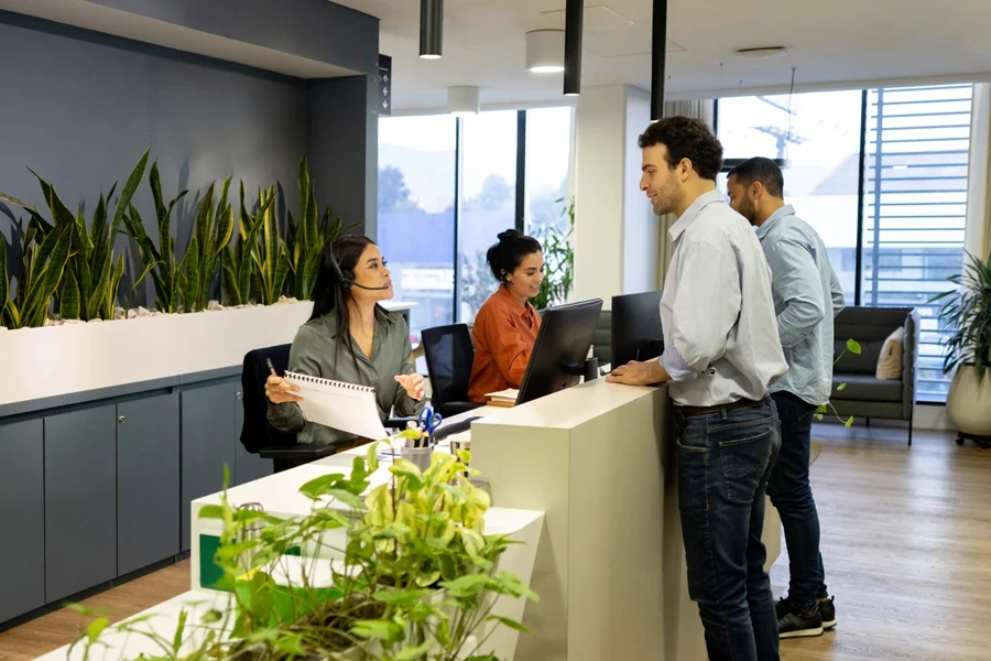 Receptionists talking to clients in an office