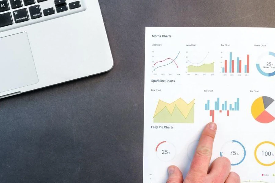 Sales data on a table near a laptop