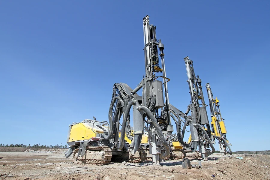 Several rock drilling machines parked on a construction site ready for use