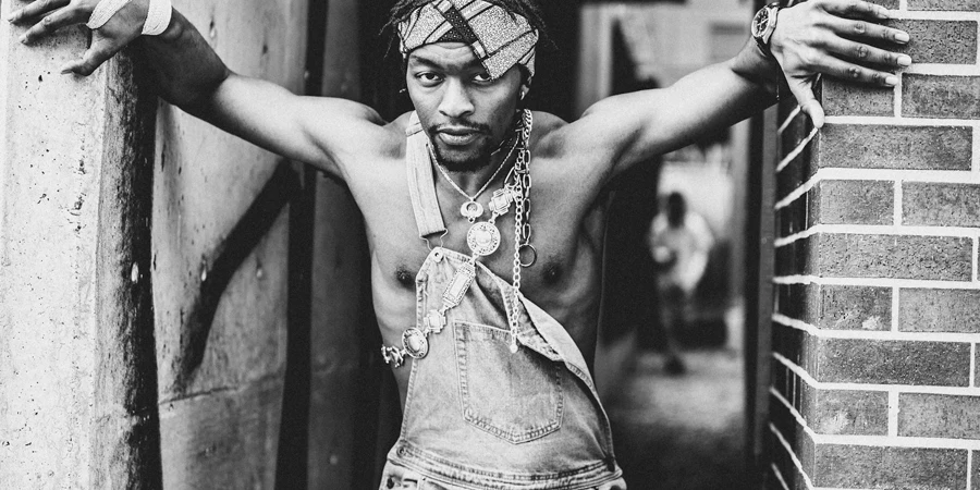 Shirtless black man with chains standing between walls