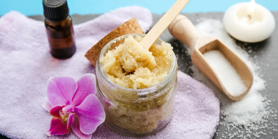 Side view of homemade sugar scrub in glass jar with ingredients for decoration