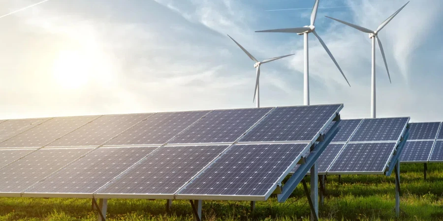 Solar panels and wind generators under blue sky on sunset