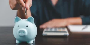 Stack of coins with piggy bank on the table