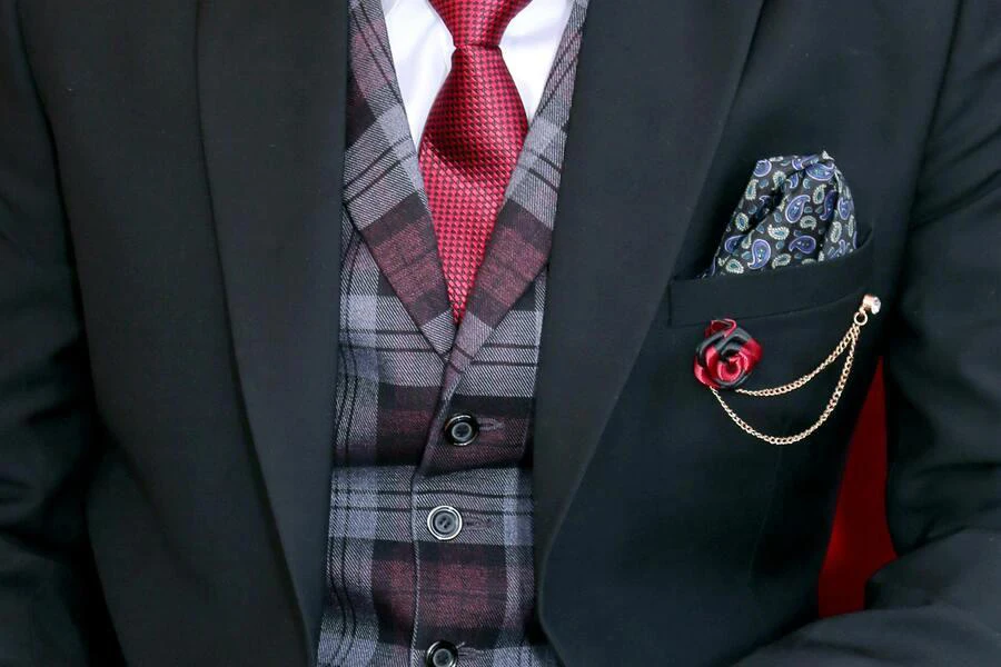Suit adorned with paisley pocket square and boutonniere with chain