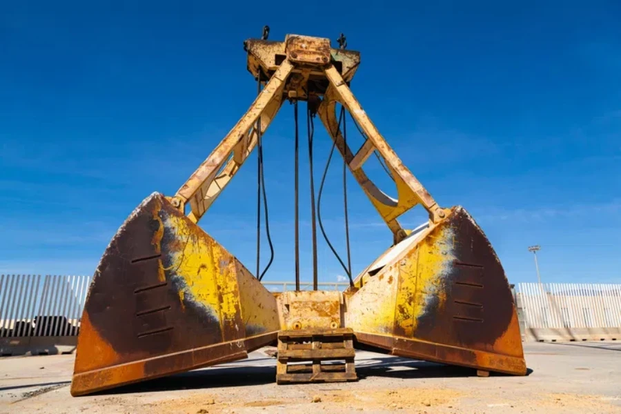 The cargo bucket stands on the territory of the seaport for unloading and unloading bulk cargo on transport vessels