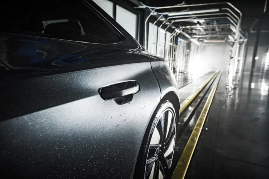 The side end of a modern car under an air blower in a touchless car wash line