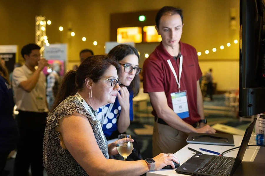 Three people looking at data on a laptop