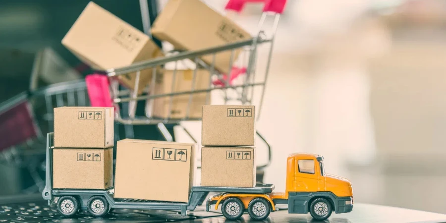 Trailer truck moves boxes of goods or cartons, a shopping cart on a laptop computer