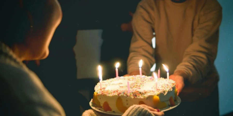 Two People Holding Cake With Lit Candles