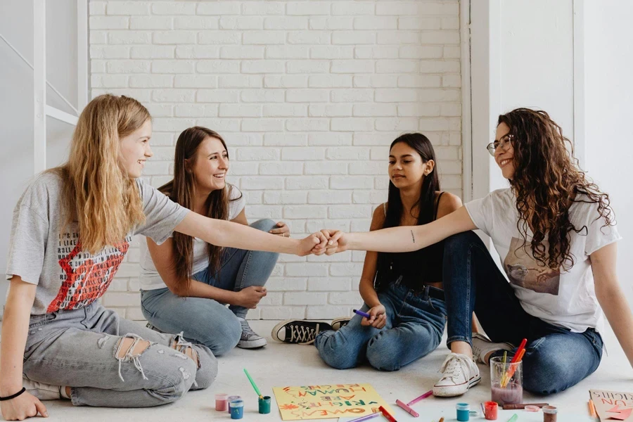 Two Teens and Two Young Women Drawing on the Floor