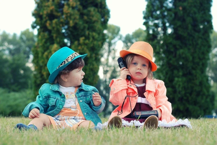 Two Toddlers Sitting on Grass Field