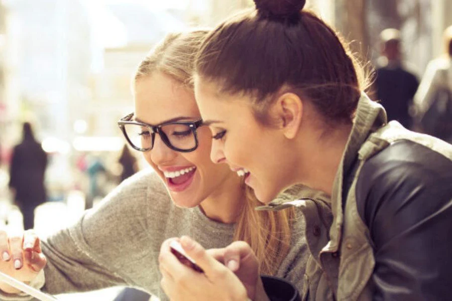 Two young women smiling at a mobile phone