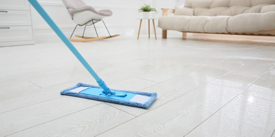 Washing of parquet floor with mop in room