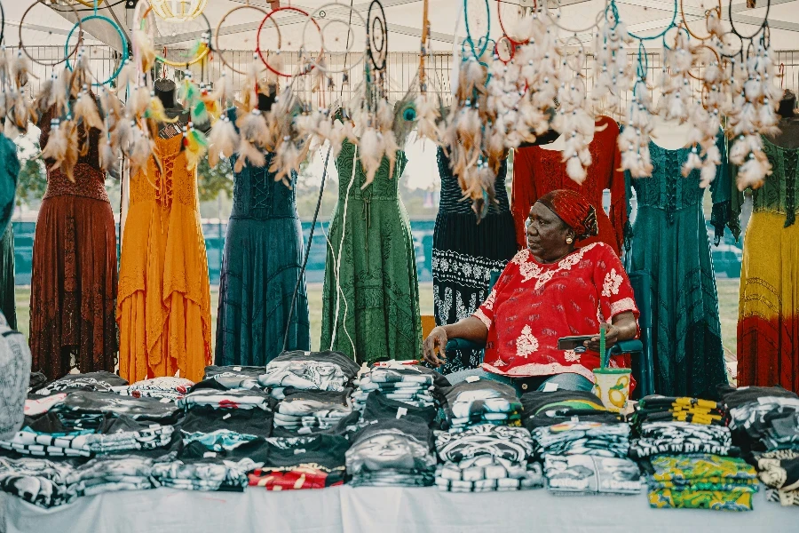 Woman Seated Next to Assorted Dresses