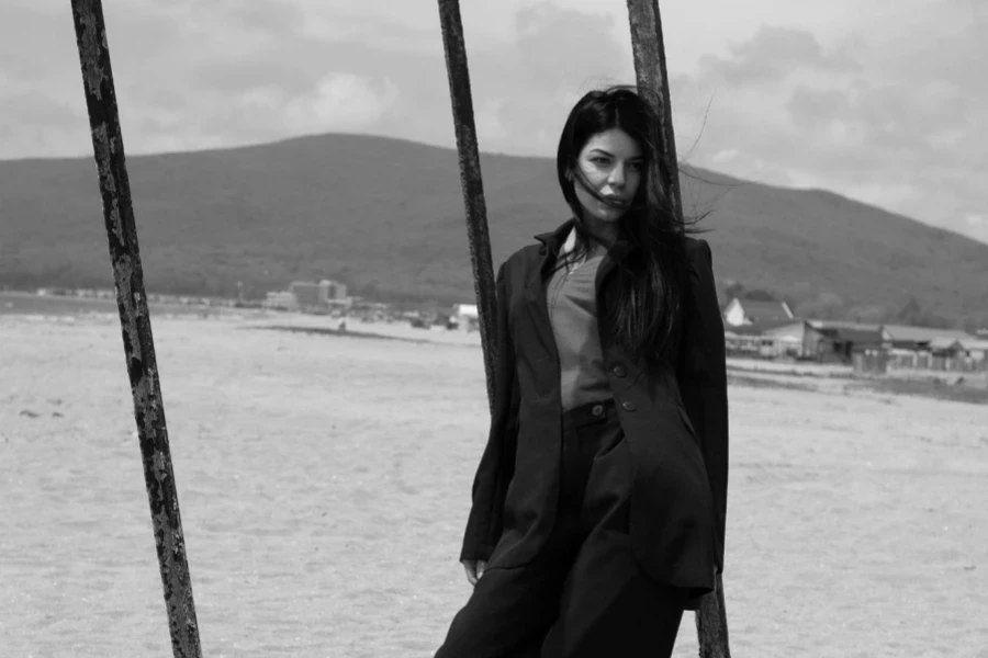 Woman Wearing an Oversized Suit Posing on the Beach