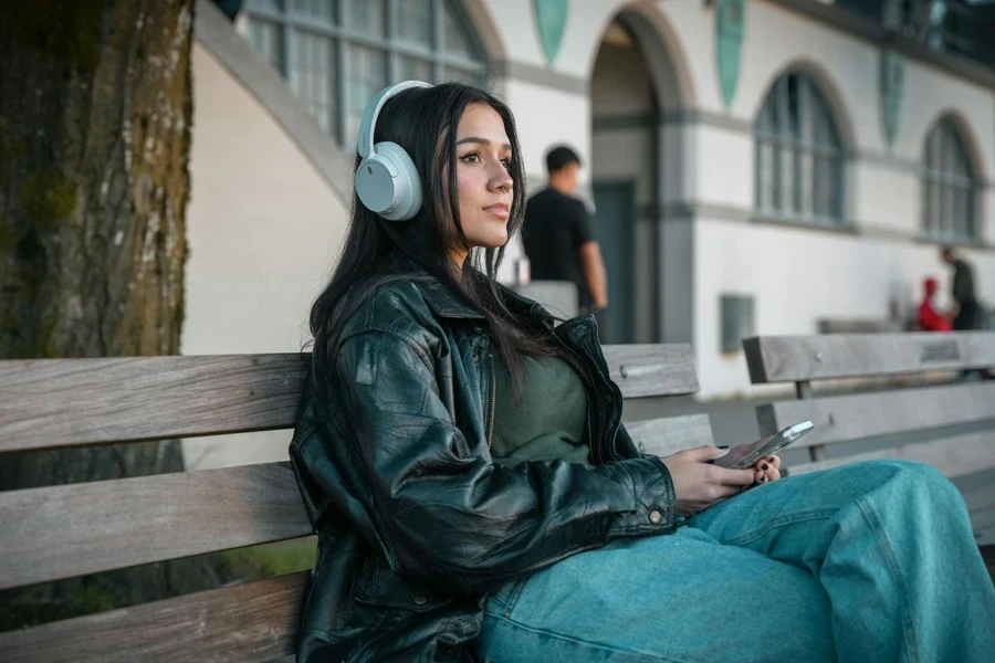 Woman With Headphones Sitting on Wooden Bench