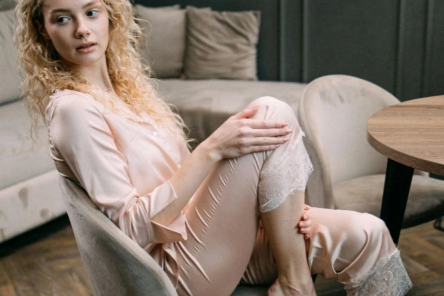 Woman in Pink Sleepwear Sitting on Beige Chair