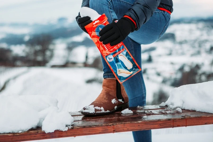 Woman opening a foot warmer packet in the cold