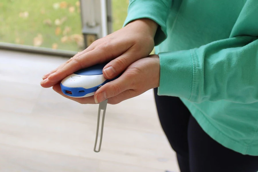 Woman placing hands on a rechargeable warmer