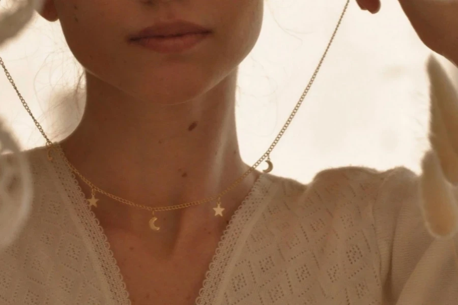 Woman putting on necklace with pendants