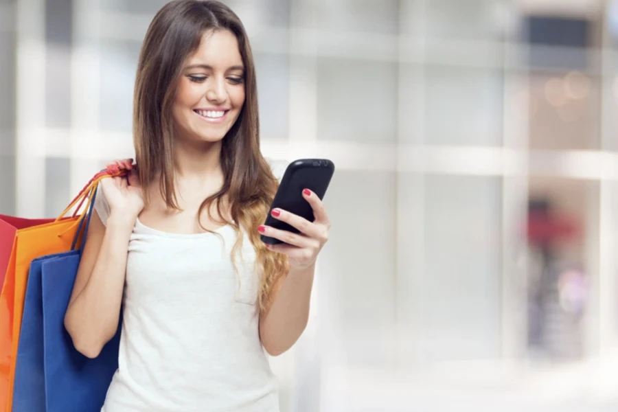 Woman smiling at her phone while shopping