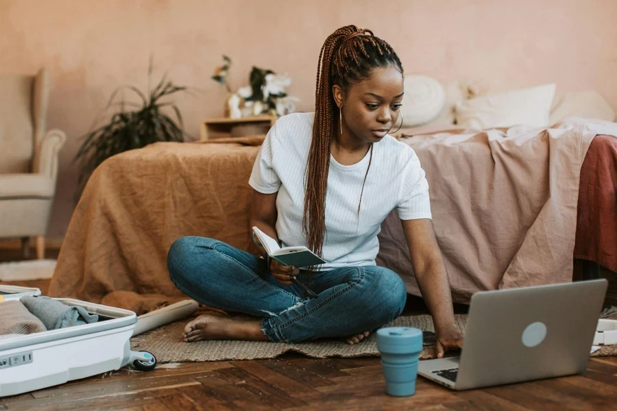 Woman with Long Brown Braided Hair Using Laptop on Floor