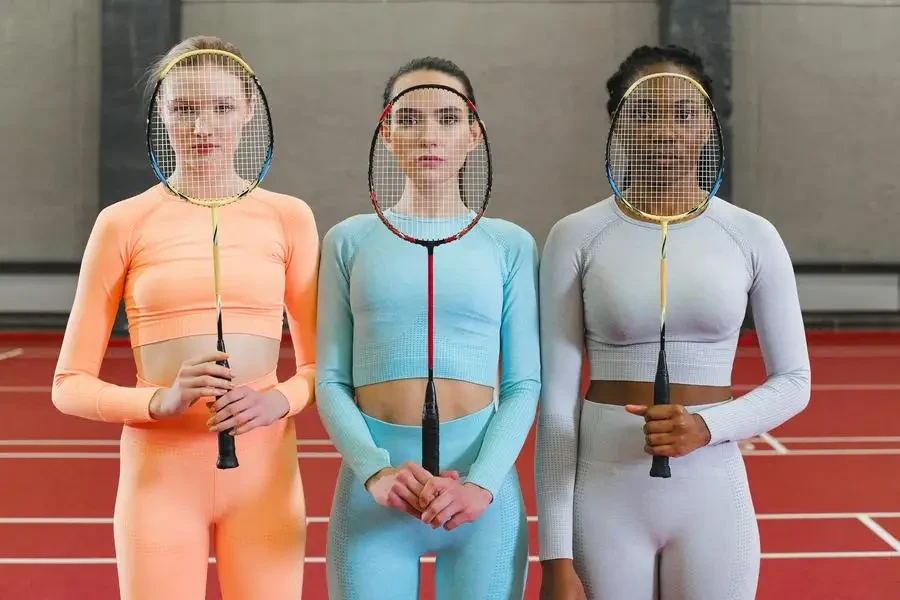 Women Standing with Badminton Rackets in Front of Their Faces by SHVETS production