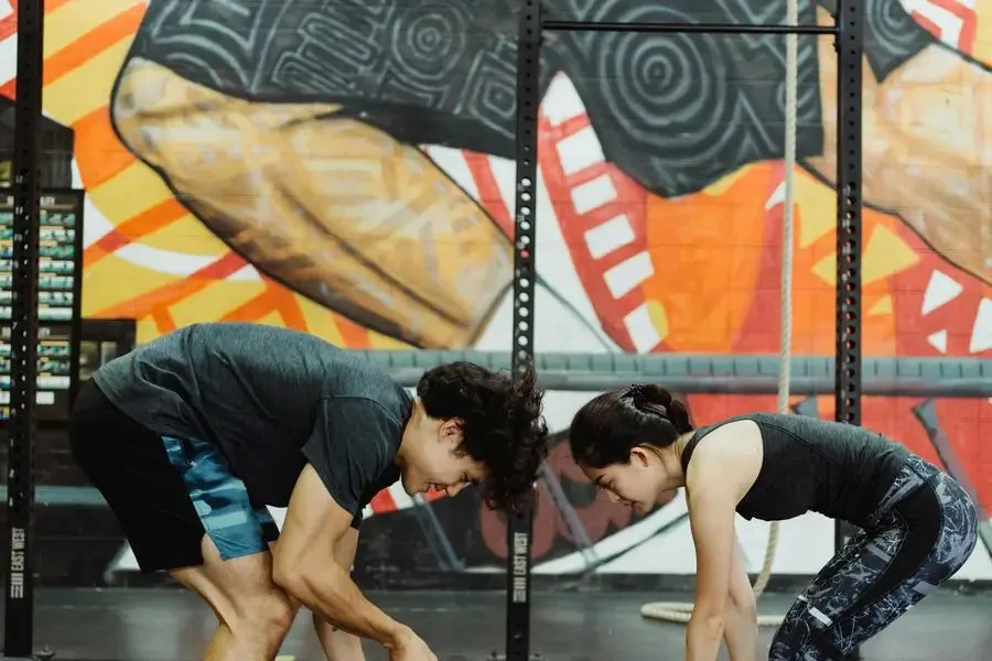 Young Athletes Lifting Weights at Gym with a Mural by Ketut Subiyanto