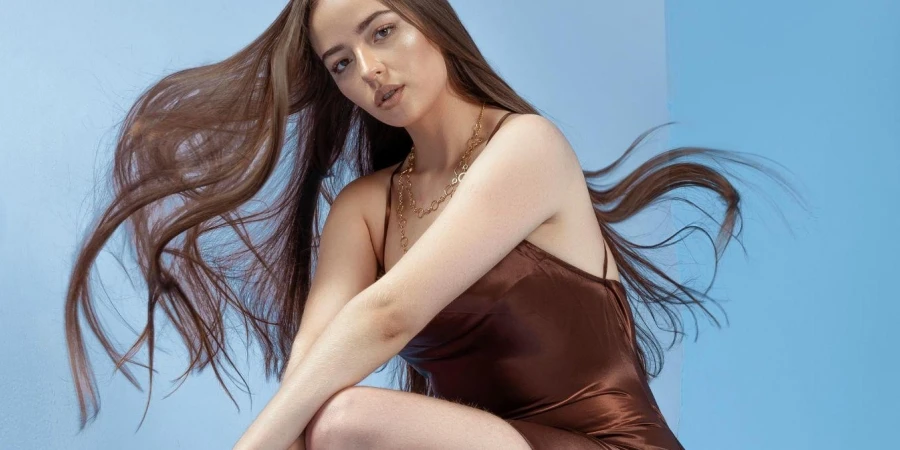 Young Woman in a Brown Dress and Heels Posing in Studio