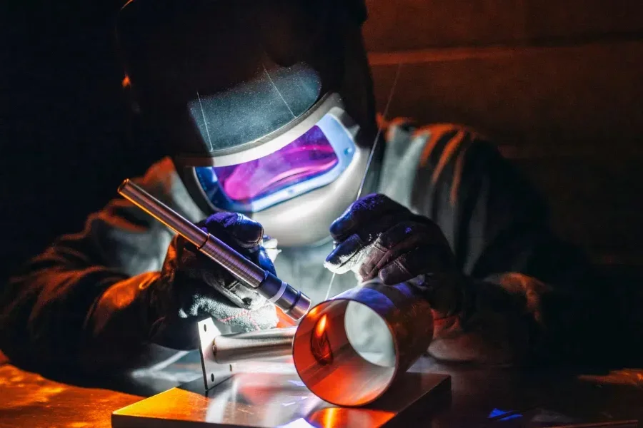 a man using a TIG  welder in a workshop