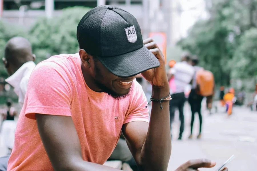 A smiling man in a black trucker hat