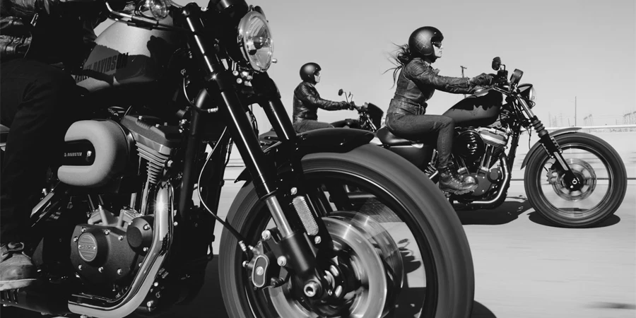 black and white photo of people riding motorcycle