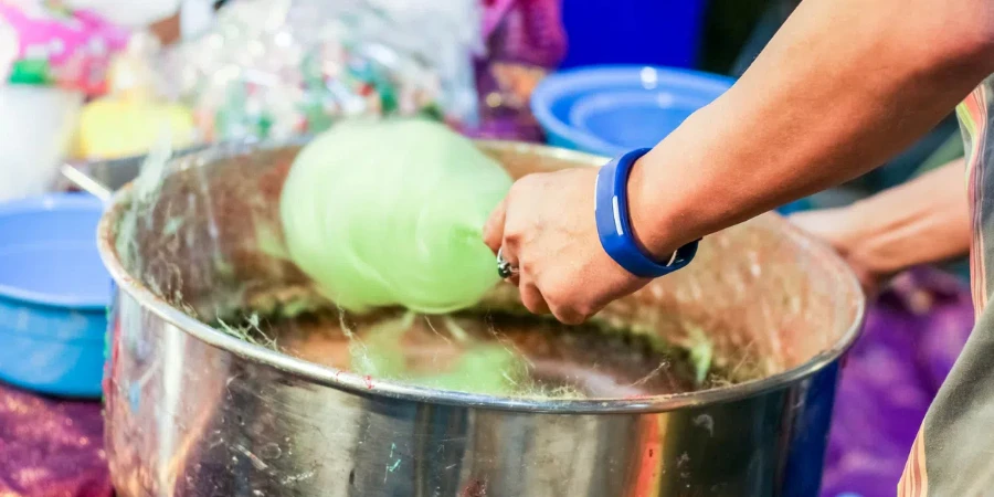 hand rolling cotton candy in candy floss machine