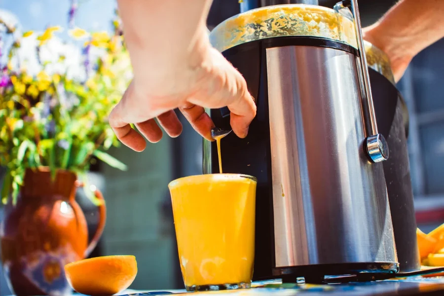 man preparing fresh orange juice