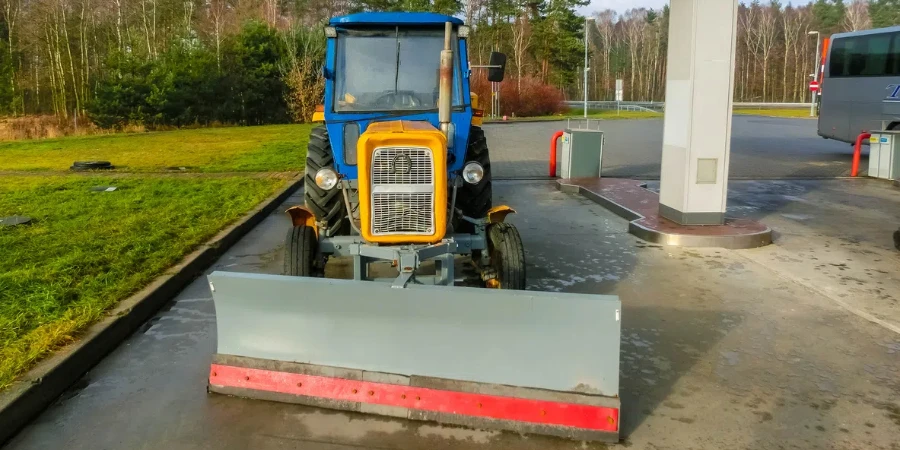 the colorful tractor is parked near the gas station