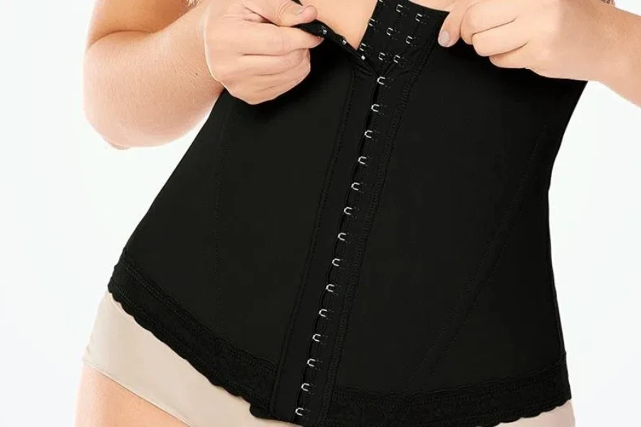 Lady fastening the closure of a waist trimmer corset