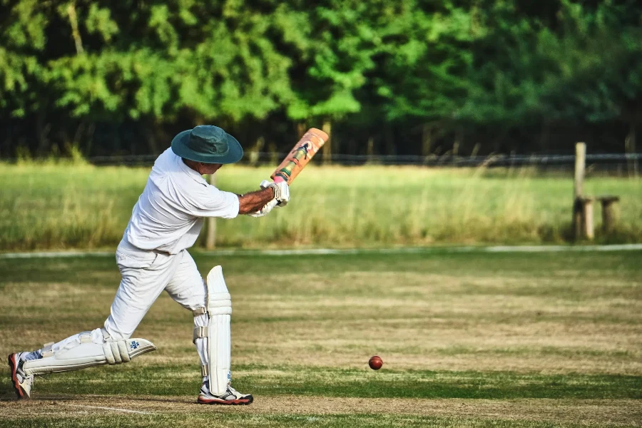Man hitting cricket ball while wearing cricket sunglasses