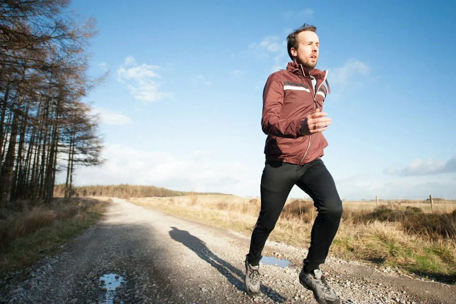 Man running along dirt track in warm clothing