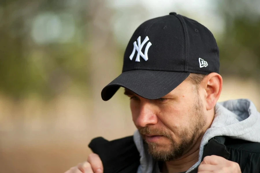 Man wearing a black Yankee baseball hat