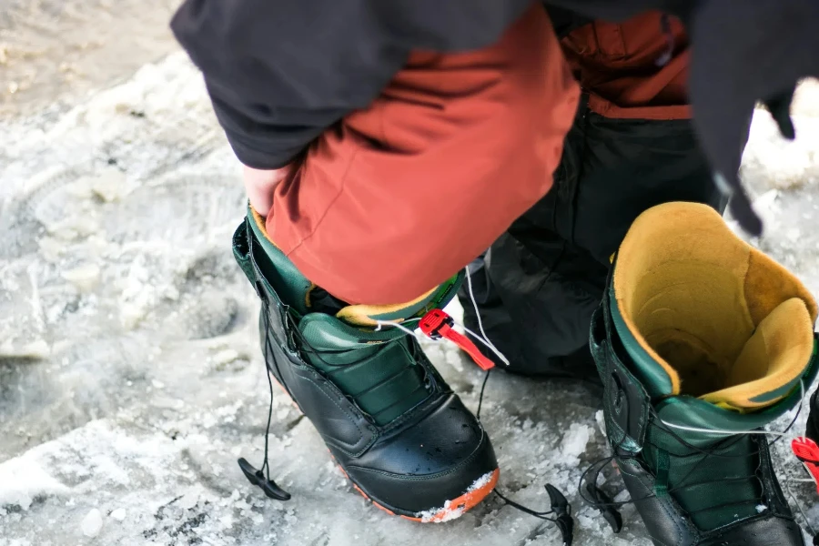 Person putting ski boots on while outside in winter