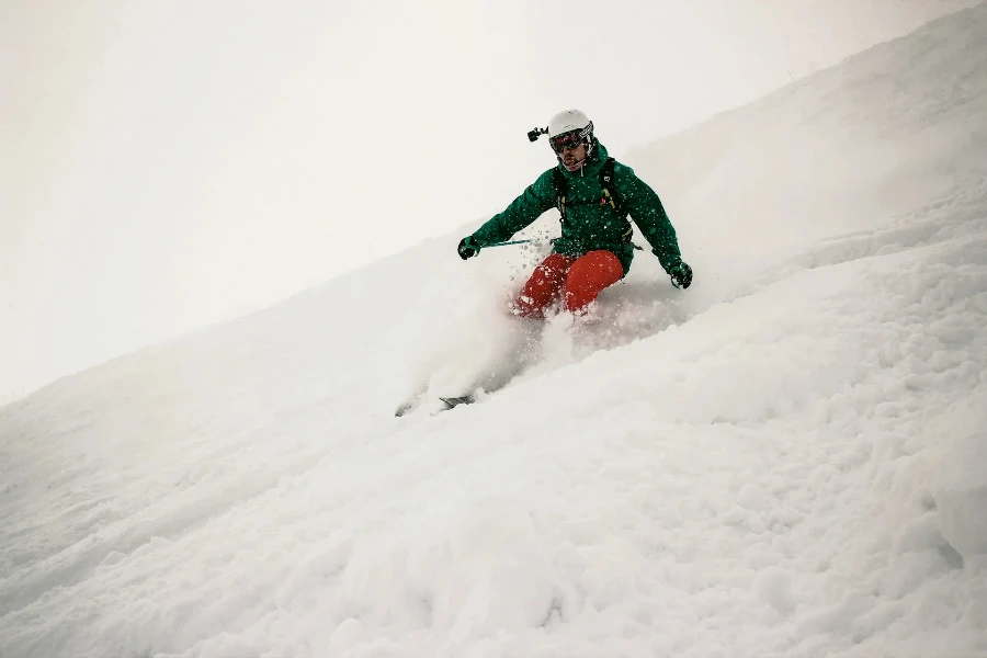 Person skiing down slope with white helmet