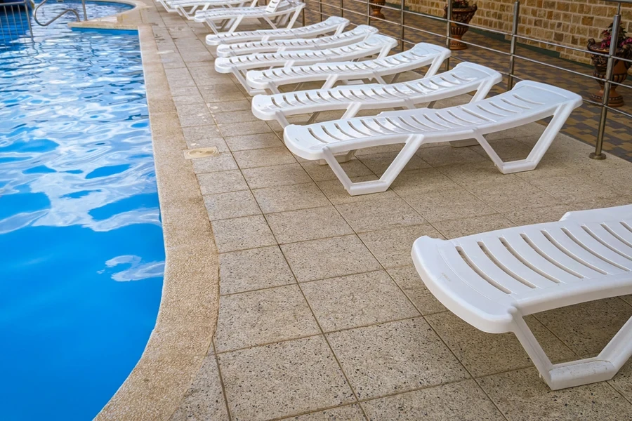 row of free plastic sunbeds at the swimming pool in a tourist resort