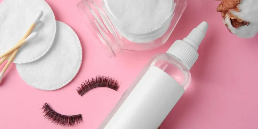 swabs and false eyelashes on pink background