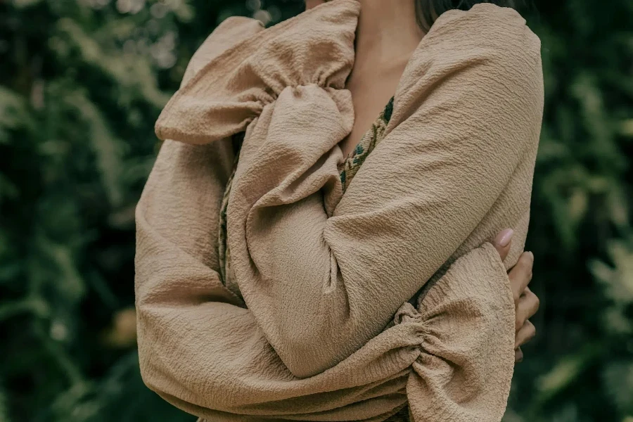 Tan women’s blouse with ruffled sleeves