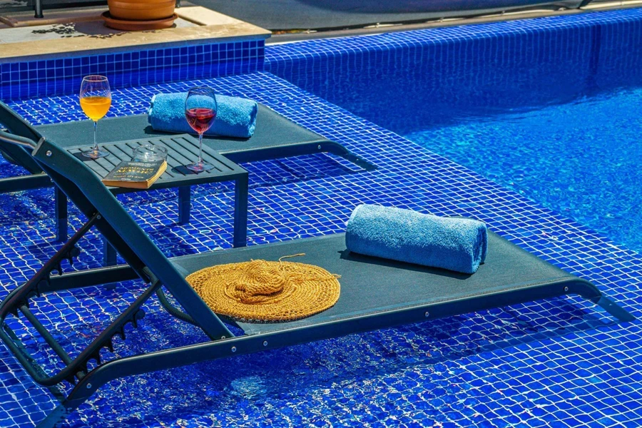 textilene lounge chairs with wine glasses by the pool