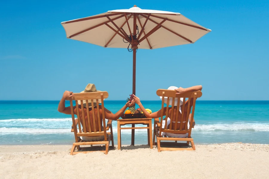 vacation couple relaxing in teak chairs by the beach